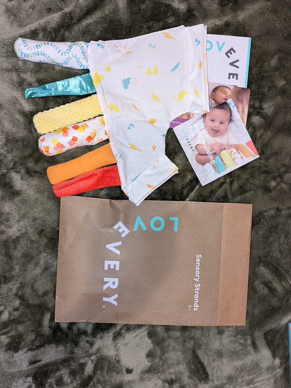 Lovevery Baby Bib with Multicolor Sensory Strands